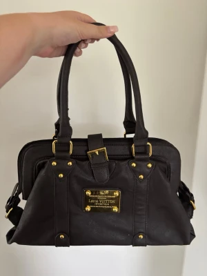 Vintage Y2K handväska - Supersnygg mörkbrun y2k väska! Får plats med mycket. Fint skick förutom en defekt på innersidan av ett av handtagen (se bilder), annars bra! Öppen för prisförslag & postar snabbt💕