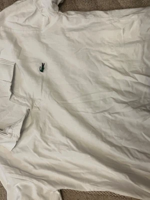 Lacoste pike - Vit Lacoste piké i storlek XL men är mer som M kanske L skulle säga mest M bara använd under en halv sommar