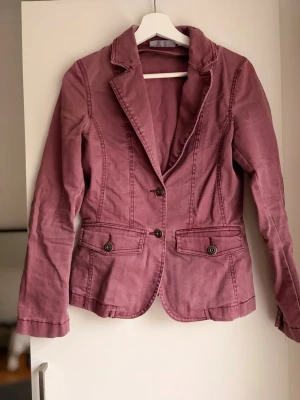 Lila jeans jacka k kavajformat - Köpt second hand, har en dragkedja på insidan för en huva, men denna saknas. 