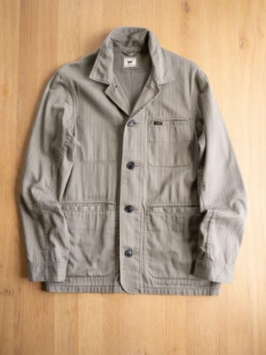 Olivgrön Chore Jacket från Lee - Stilren olivgrön overshirt från Lee med tre stora utanpåfickor och en mindre bröstficka. Klassisk krage och knäppning med fyra svarta knappar framtill. Tillverkad i slitstark bomull, perfekt för lager på lager och en avslappnad look.