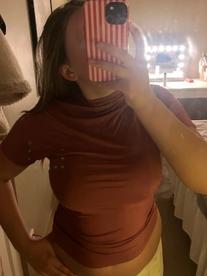 Mörkrosa polotopp med kort ärm - Säljer en mörkrosa polotopp med korta ärmar. Toppen har en tight passform och är tillverkad i ett mjukt, stretchigt material som sitter snyggt mot kroppen. Perfekt att styla med jeans eller kjol för en trendig look.