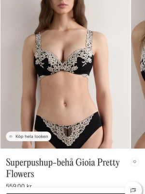Svart superpushup-bh med spets - Supersnygg svart superpushup-bh med vadderade kupor och dekorativ beige spets i blommönster. Bh:n har breda axelband med spetsdetaljer och ger extra lyft och form. Perfekt för dig som vill ha en feminin och lyxig look.