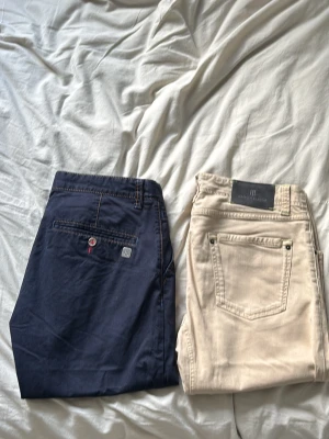 2x Hansen&jacob jeans - Säljer två par stilrena Hansen & Jacob jeans i mörkblå och beige färg. Båda är i fint skick och har en clean, klassisk design som passar både till vardags och en mer uppklädd stil.  Tillverkade i en bekväm bomullsblandning med lite stretch för bra passform och komfort. Ett perfekt val för dig som vill ha kvalitetsjeans som håller länge. Pris: 1 för 699 2 för 999 