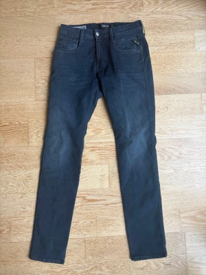 Mörkblå Replay hyperflex slim fit jeans - Snygga mörkblå Replay hyperflex slim fit jeans med klassisk femficksdesign och dragkedja på myntfickan. W28 och L32. Jeansen har raka ben för en modern look. Perfekta för dig som gillar en stilren och enkel outfit.