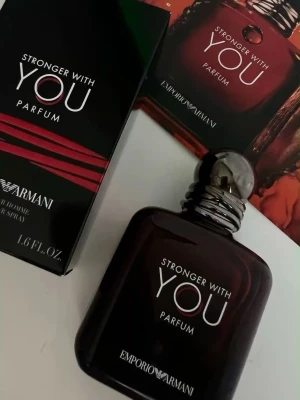 Stronger With You Parfum Armani - Stronger With You Parfum från Emporio Armani har en elegant, mörkbrun glasflaska med rundade former och en metallisk kork. Doften är intensiv och modern, perfekt för dig som vill sticka ut. Flaskan har stilren vit text och en lyxig känsla.