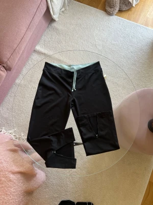 Tränings capris  - Snygga trendiga trekvartstights med bred turkos midjeresår och dragsko. De är i storlek 38 och är från Soc! Några år gamla men använda typ 1 gång så inget som syns. 