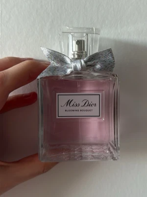 Miss Dior Blooming Bouquet parfym 100 ml  - Miss Dior Blooming Bouquet parfym i en elegant, fyrkantig glasflaska med ljusrosa doft och en söt silverfärgad rosett runt halsen. Flaskan har en stilren etikett framtill och spraymunstycke i silver. Perfekt för dig som gillar fräscha och blommiga dofter. Testad nån enstaka gång och säljer då det inte är min typ av doft. Nypris 1699 kr. 