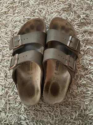 Bruna Birkenstock sandaler med spännen - Ett par birkenstock som är lite slitna men dom är jättesköna för foten och formar foten perfekt 