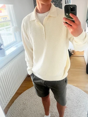 Vit stickad tröja med krage - Säljer en vit stickad tröja med krage och knappar framtill. Tröjan har en avslappnad passform och är gjord i ett mjukt, strukturerat material. Perfekt för dig som gillar en clean och enkel stil. Knappt använd och köpt för 599