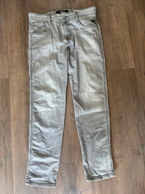 Gråa Replay jeans - Snygga gråa slim fit jeans med klassisk femficksdesign och raka ben. Jeansen har bälteshällor, dragkedjegylf och subtila sömdetaljer på bakfickorna. Perfekta för en avslappnad och trendig look.