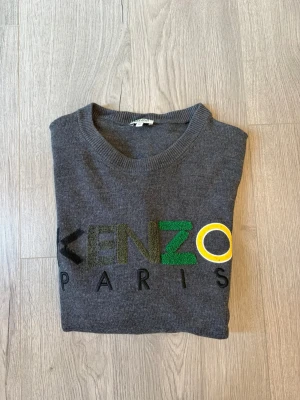 Grå stickad Kenzo-tröja - Snygg grå stickad tröja från Kenzo! Tröjan är XL men kan också passa en L📏 Tröjan är använd men har inga defkter! Skriv vid minsta fundering!✅ fraktar inom 24h🚚📦