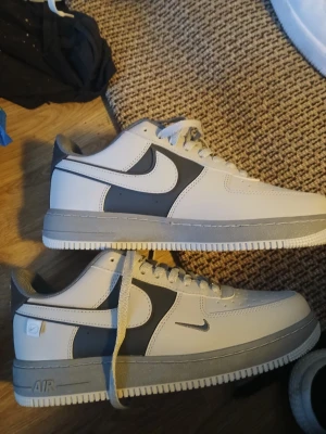  Nike air force 1 sneakers nyskick  - Snygga gråa Nike air force 1  sneakers med klassisk swoosh på sidan. Skorna har lågt skaft, vita snören och grå detaljer på sulan och hälen. Tillverkade i slittåligt material med stilren design som passar till det mesta. Storlek 42. Nyskick använda endast 3ggr.  Absolut toppskick. 