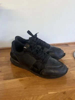 Sneakers - Svarta sneakers i Rockrunner-modell. Storlek 42. Använda och har tydliga tecken på användning, se bilderna för skick. Säljs utan originalkartong.