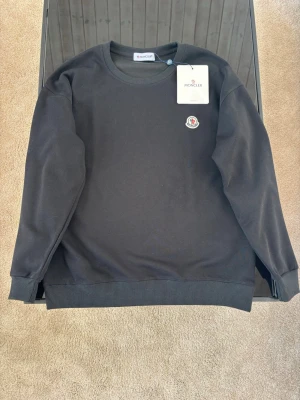Svart moncler tröja - Svart moncler tröja ny. Den är i storlek M men passar även S. Tröjan är i 10/10 skick. Skriv frågor vid funderingar! Priset är inte hugget i sten🚨