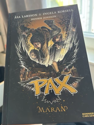 PAX Maran & Grimmen bokpaket - Två spännande böcker ur PAX-serien av Åsa Larsson och Ingela Korsell, illustrerade av Henrik Jonsson. Omslagen är färgstarka med dramatiska illustrationer, en i svart och gult och en i svart och lila. Perfekta för dig som gillar äventyr och mystik.