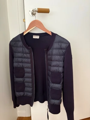 Mörkblå cardiganjacka från Moncler - Moncler cardigan i bra skick. Sömmen har gått av där vid lappen en gång så därför en söm genom lappen annars inga större defekter