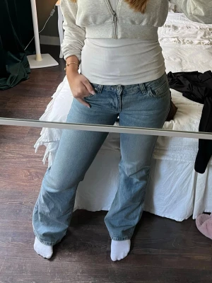 Ljusblå bootcut jeans - Säljer ett par ljusblå bootcut jeans med klassisk femficksmodell och normal midja. Jeansen har en avslappnad passform över låren och lätt utsvängda ben. Perfekta till en casual look och passar till det mesta i garderoben.