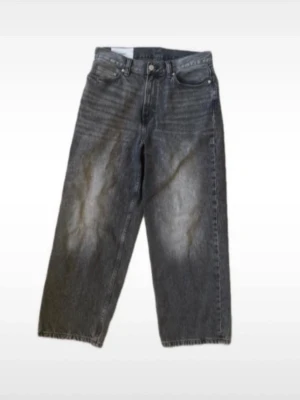 Grå loose fit baggy jeans  - Säljer ett par gråa jeans med loose fit och raka ben. Jeansen har klassisk femficksdesign och knappgylf. Perfekta för en avslappnad och trendig stil. Materialet är robust denim och färgen har en snygg tvättad look.