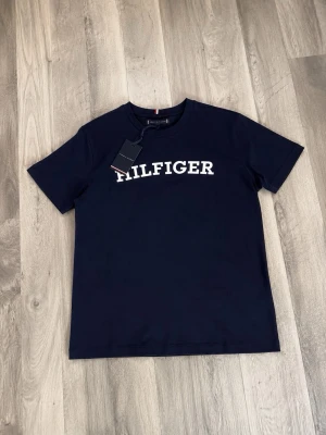 Mörkblå Hilfiger t-shirt - Tommy Hilfiger T-shirt 👕🔥  Säljer en snygg Tommy Hilfiger T-shirt i mycket bra skick. • Storlek: 164 • Märke: Tommy Hilfiger • Pris: 400 kr • Skick: Mycket bra skick • Originaletiketten/lappen som följde med tröjan finns kvar 🏷️  Snygg och stilren T-shirt som passar perfekt till jeans eller shorts. Packas noggrant och skickas snabbt 📦
