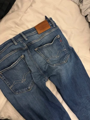 Blå jeans från Replay - Säljer ett par klassiska blå jeans från Replay med raka ben och snygga kontrastsömmar. Replay-läderpatch i midjan. Perfekta för en avslappnad och trendig look. Längdern är 34 och w32