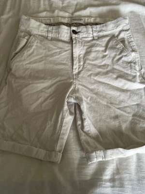 Beige shorts från Jack & Jones - Snygga beige shorts från Jack & Jones med klassisk passform, fickor på sidorna och uppvikta benslut. Mycket fint skick.