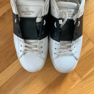 Valentino Sneakers - Sneakers från Valentino köpta förra året, från deras hemsida. Vita i läder med svart ”detaljband” och vita nitar bak. Super snygga! Strl 39,5 