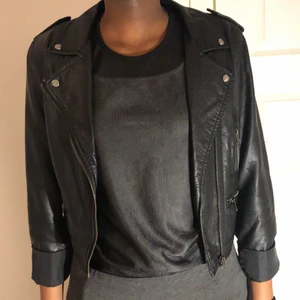 Svart skinnjacka storlek XS - Svart skinnjacka i storlek XS. Köpt från JC längesen. Svarta linnet under jackan får du på köpet. Den är ganska genomskinlig men fint med en svart BH under. Jackan är knappt använd. 