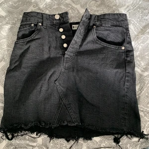 Jeans kjol - Svart jeanskjol med slitningar nedtill. Den här är helt ny och oanvänd och den är i storlek 36