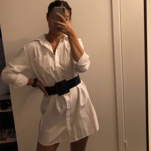 Vit skjortklänning nakd - En fin skjortklänning från Hanna schönbergs kollektion med nakd. Knappt använd och ser ut som ny. Fin med bälte i midjan eller som överdragsklänning till stranden✨ passar alla mellan xs-m beroende på hur man vill att den ska sitta. Obs bältet medföljer ej