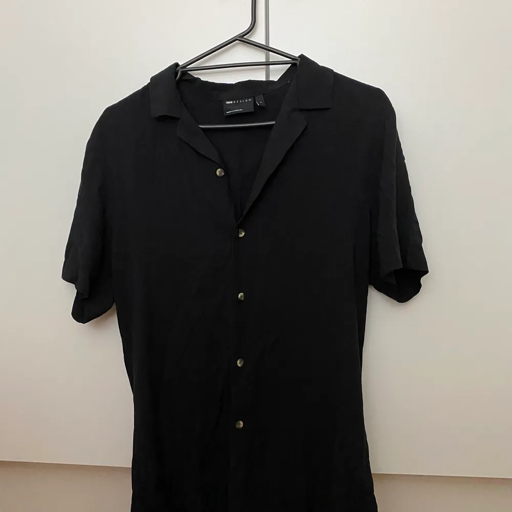 En vanlig svart skjorta som är från herrsidan på ASOS. Den är i storlek small men eftersom den är från herr så ör den oversized. Skitsnygg att ha uppknäppt över ett vitt kroppat linne och vanliga jeans. Säljer för kommer inte till användning längre men är i toppenskick! Köparen står för frakt 📦 . Skjortor.
