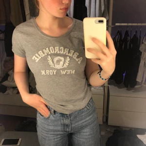 Abercrombie & fitch T-shirt  - En lite tjockare T-shirt ifrån Abercrombie & fitch med märket på bröstet. Ett litet hål men inget man tänker på, se bild två. Annars i bra skick. I stl L, men skulle snarare säga att den passar en s/m bättre! Köparen står för frakten😇