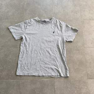 En grå T-shirt från kidsbrandstore, märke Polo Ralph Lauren, nästan helt oanvänd. 