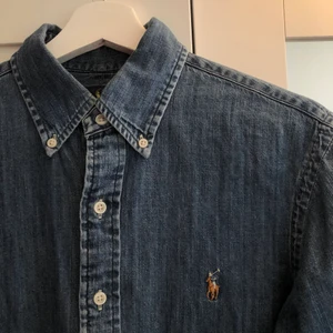 Ralph Lauren Polo Skjorta - Ralph Lauren-skjorta i jeansmaterial. Mellanljus tvätt. S i slim fit, passar även XS. Lite använd, i gott skick. Köpt 2019