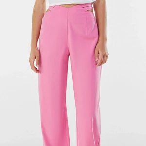 Rosa kostymbyxor - Rosa kostymbyxor med detaljer vid höfterna! Helt oanvända med prislappen kvar då de var för långa! Slutsålda på hemsidan