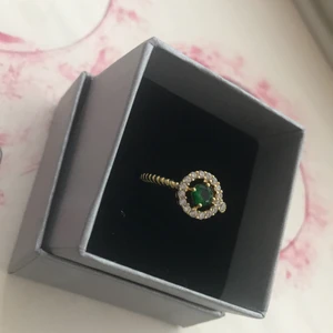 Ring med grön dekorations diamant - Ring i guldplätering. Jag fick den här av någon men kom aldrig till användning. Storleken skulle jag säga är mer som M. Den är som sagt pyttelite stor för mig. Eftersom jag inte vet dens officiella storlek så mätte och fick måttet ≈ 6cm om mitt finger. Kan säljas billigare. Köparen står för frakten och vilket paket. Ringen finns på ur och penn för 79-150 kr