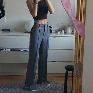 Gråa kostymbyxor  - Intressekoll på dessa snygga kostymbyxor ifrån Nakd med en slits nere vid foten😍. Jag är 165,5 och bär dessa i strl 32 som är slutsåld på hemsidan. Dessa passar en 32/34 skulle jag säga! Dem är köpta för 500kr och inte använda mer än 3 gånger! (Alltså i nyskick) säljes för 400kr med frakt ink🤍