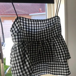 Topp - Rutigt linne med volanger. Jättebra skick. Storlek M. Köparen står för frakten.