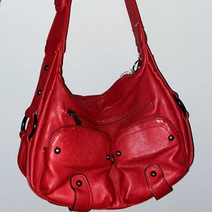 Röd väska - Säljer min jättefina röda väska. Säljer den pga att den inte kommer till användning💕 Den är i fint skick med nått smått märke någonstans men det syns verkligen inte!💕frakten kostar 45kr💕