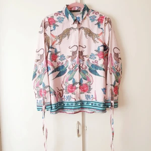 Trendig skjorta - 🌷FÖRST TILL KVARN!🌷Unik trendig skjorta med coolaste kreativa motivet på fram och baksidan. Knyts vid ärmsluten till små rosetter. Har endast testat. Oerhört fin i georgous skick!🦚 Pris:120+frakt💕