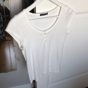 T-shirt  - Säljer den här jättejättefina tröjan som jag köpte på brandy melville för några månader sedan. Den är verkligen superfin och i jättebra skick eftersom den aldrig blivit använd! Säljer den eftersom att jag aldrig använder den. Köpte för ungefär 270kr har jag för mig! 