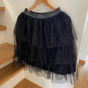 Skit fin svart glittrig volangkjol i storlek 170, vilket motsvarar S/M. Så fin nu till vintern med stickad tröja och ugg!!💗