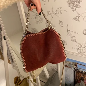 Stella McCartney falabella mini - Säljer min vinröda Stella McCartney mini falabella väska, helt äkta. Väl använd men ändå i bra skick, inga större defekter förutom två små mörka fläckar (syns på bild 2, i mitten längst upp precis under ”sömmen”) samt att färgen försvunnit lite på dem korta kedjorna. Minns inte exakt vad nypris är men någonstans runt 6 - 7 000. Hör av dig för fler bilder, pris kan diskuteras 💕