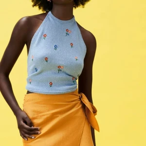 Stickad topp med halterneck  - Stickad topp med halterneck ljusblå med broderade blommor från zara. Aldrig använd och nypris är 199kr. 