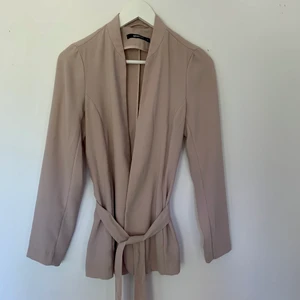 Sommarjacka i beige/ knytband/ kavaj/ storlek 36 - Beige kavaj/ sommarjacka med knytband från Ginatricot. Använd max 3 gånger, så i nyskick. Fin beige färg som passar bra på sommaren. Storlek 36.