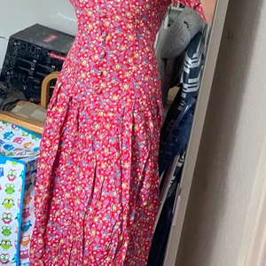 Blommig klänning - Blommig klänning i 70-tals stil med axelvaddar som inte har kommit till användning längre. 