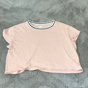 Rosa T-shirt  - En rosa magtröja med lite högre krage med svart och vitt. Tröjan är i storlek 134/140 men är stor i storleken, så den passar även 152