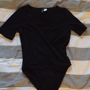 En omlott body - En svart omlott body från H&M.                                          Köparen står för frakten.