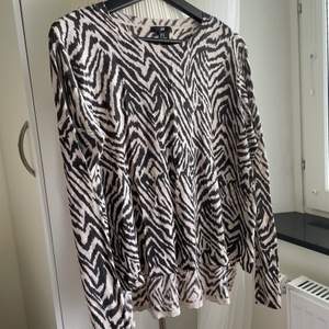 Soft thin material, long sleeved shirt that is also long at the back, animal print, brown