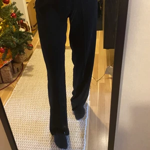 Svarta kostymbyxor - Ett par svarta kostymbyxor från chiquelle. Dragkedja i sidan, två ”låtsas”-fickor bak. Strl 36. Köparen står för frakten.