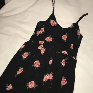 Svart klänning med blommor strl 34 - Svart klänning med rosa blommor ifrån h&m i storlek 34/XS, passar även S. Justerbara band och stretch i ryggen💖